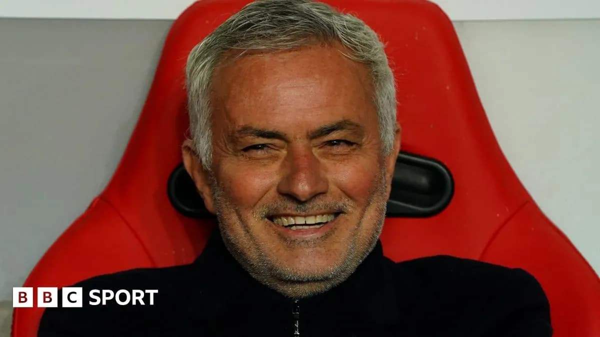 Entrenador sonriendo en el banquillo de su equipo