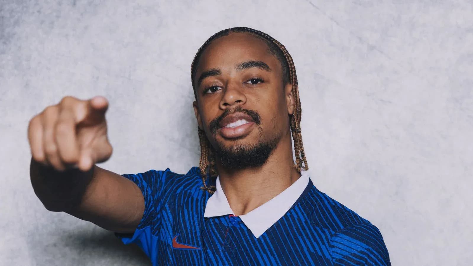 Jugador señalando mientras viste camiseta azul