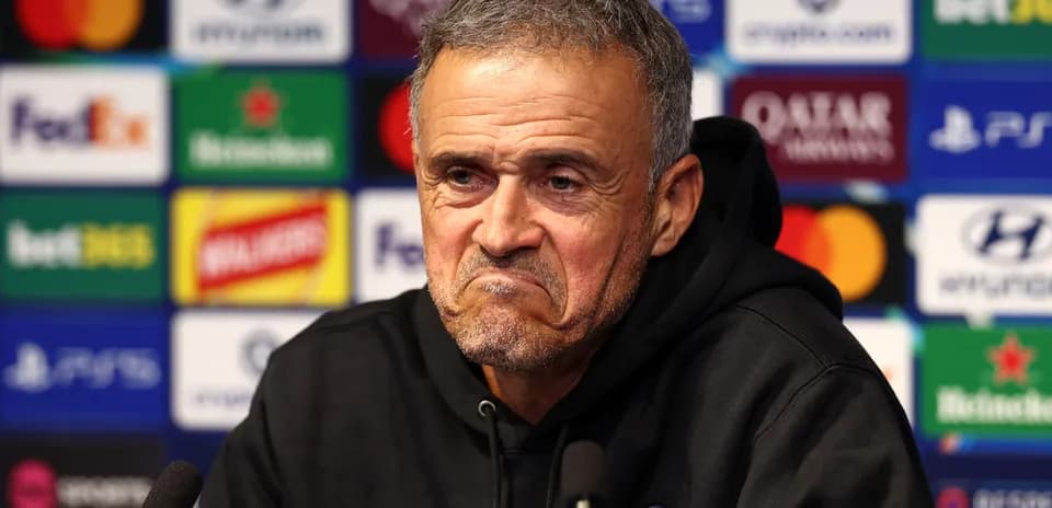 Entrenador en conferencia de prensa con fondo de patrocinadores