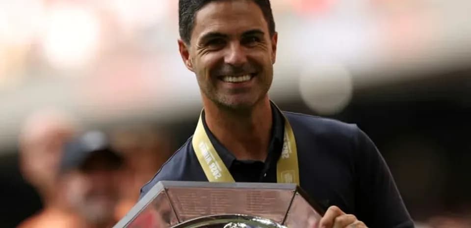 Entrenador sosteniendo trofeo en celebración
