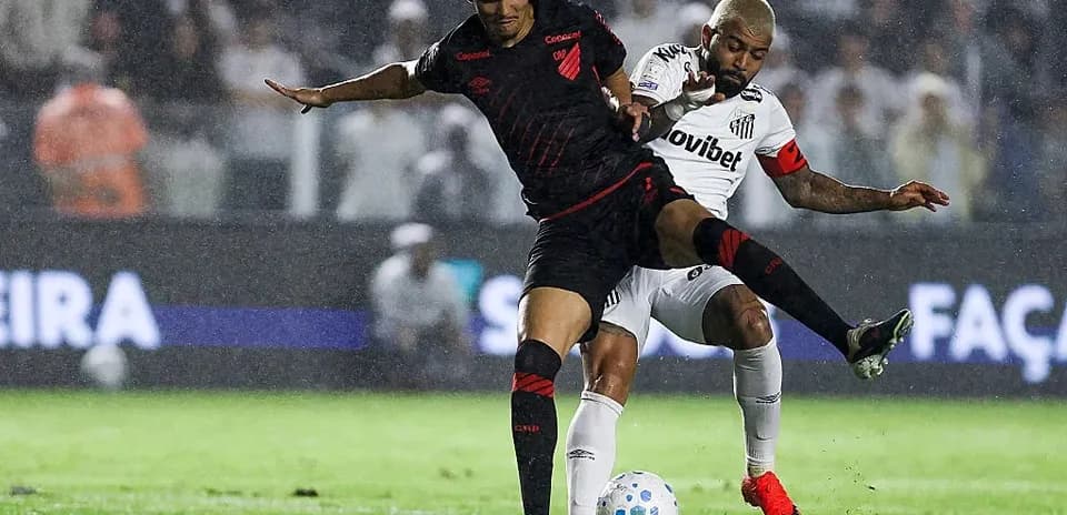 Jugador de Athletico Paranaense desafiando a jugador de Santos