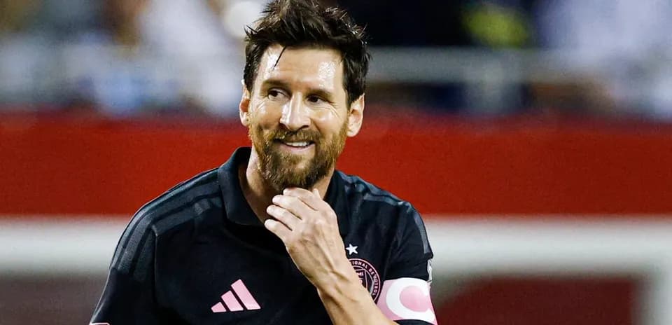 Jugador con camiseta negra sonriendo en el campo