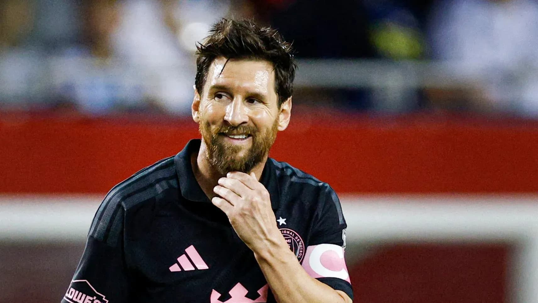 Jugador con camiseta negra sonriendo en el campo