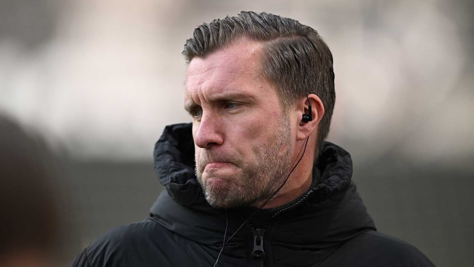 Entrenador con auriculares en el campo de entrenamiento