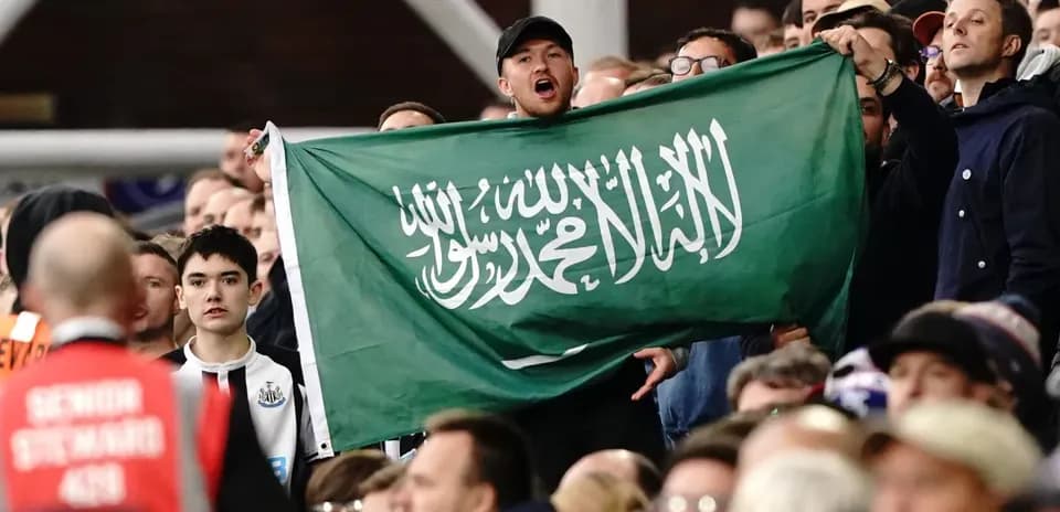 Afanático sosteniendo una bandera de Arabia Saudita en el estadio