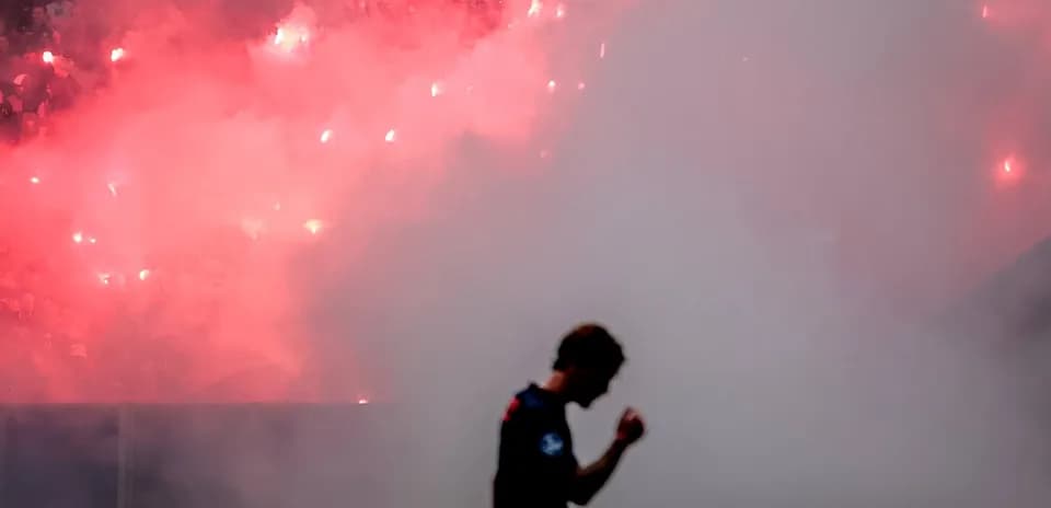 Jugador caminando con humo y bengalas de fondo