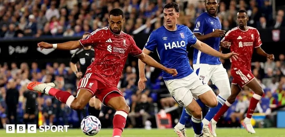 Jugador de Liverpool disparando ante defensa rival