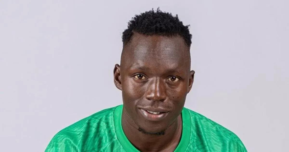 Portero sonriendo con camiseta verde en fondo neutro