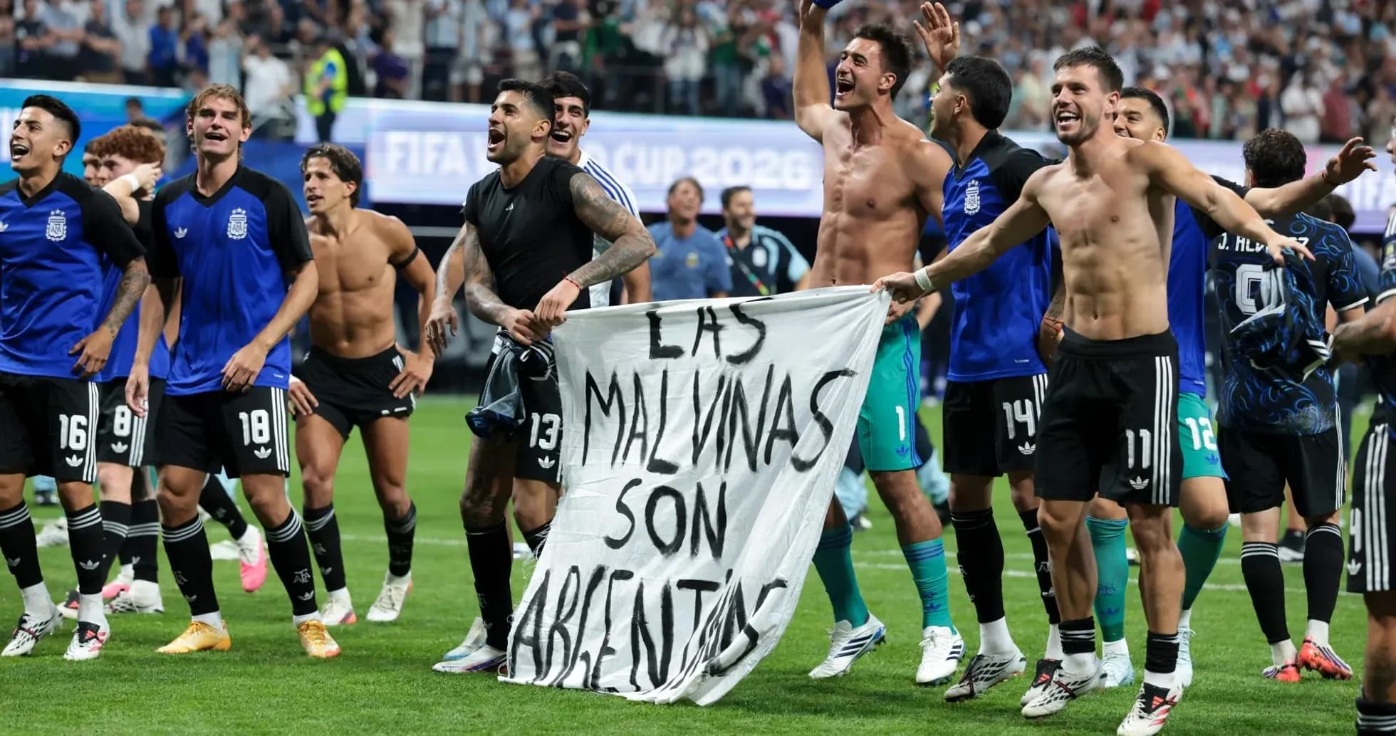 Jugadores argentinos celebrando con una bandera en el campo