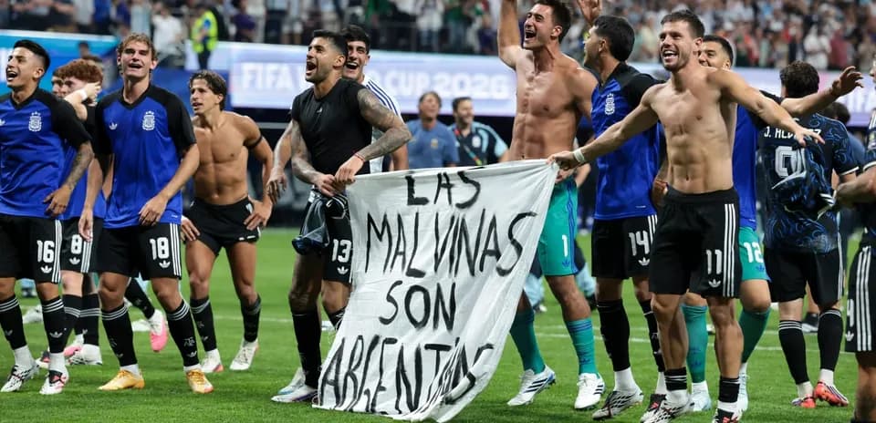 Jugadores argentinos celebrando con una bandera en el campo