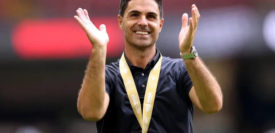 Entrenador aplaudiendo con medalla al cuello