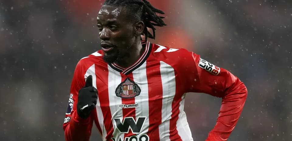 Jugador de Sunderland corriendo en campo lluvioso