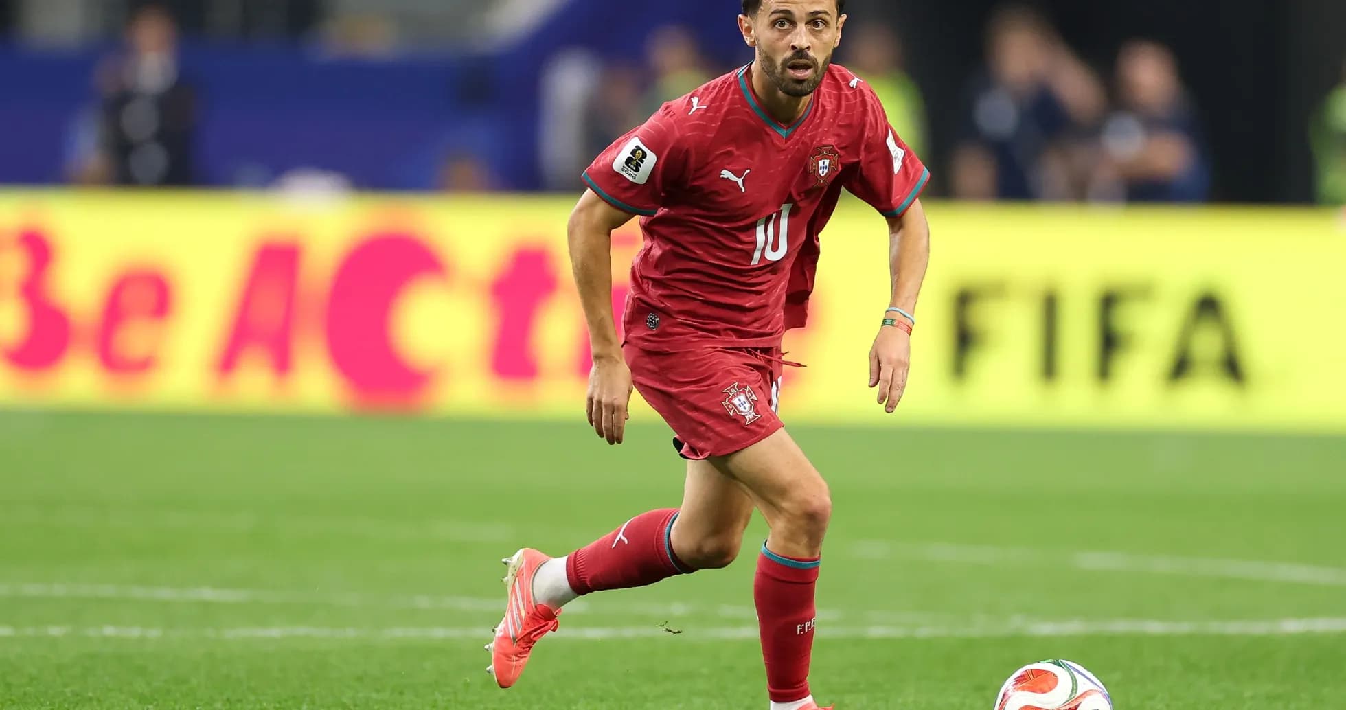 Jugador de Portugal corriendo con balón en el campo