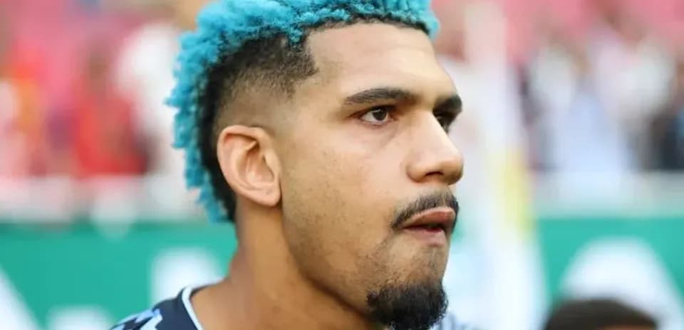 Portero con cabello azul en el campo de fútbol