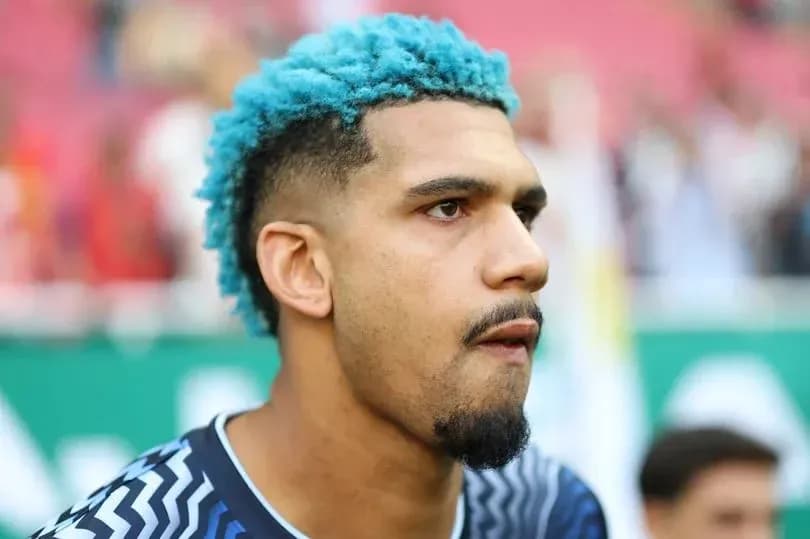 Portero con cabello azul en el campo de fútbol