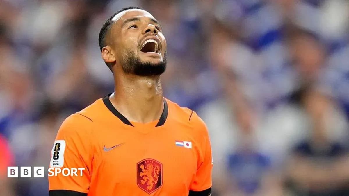 Jugador de fútbol en uniforme naranja mirando hacia arriba