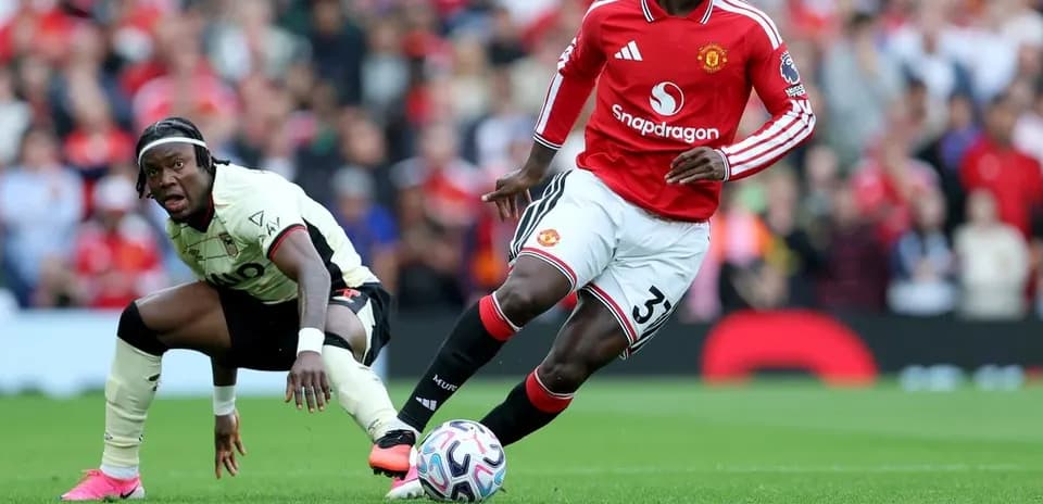 Jugador de Manchester United driblando el balón en partido