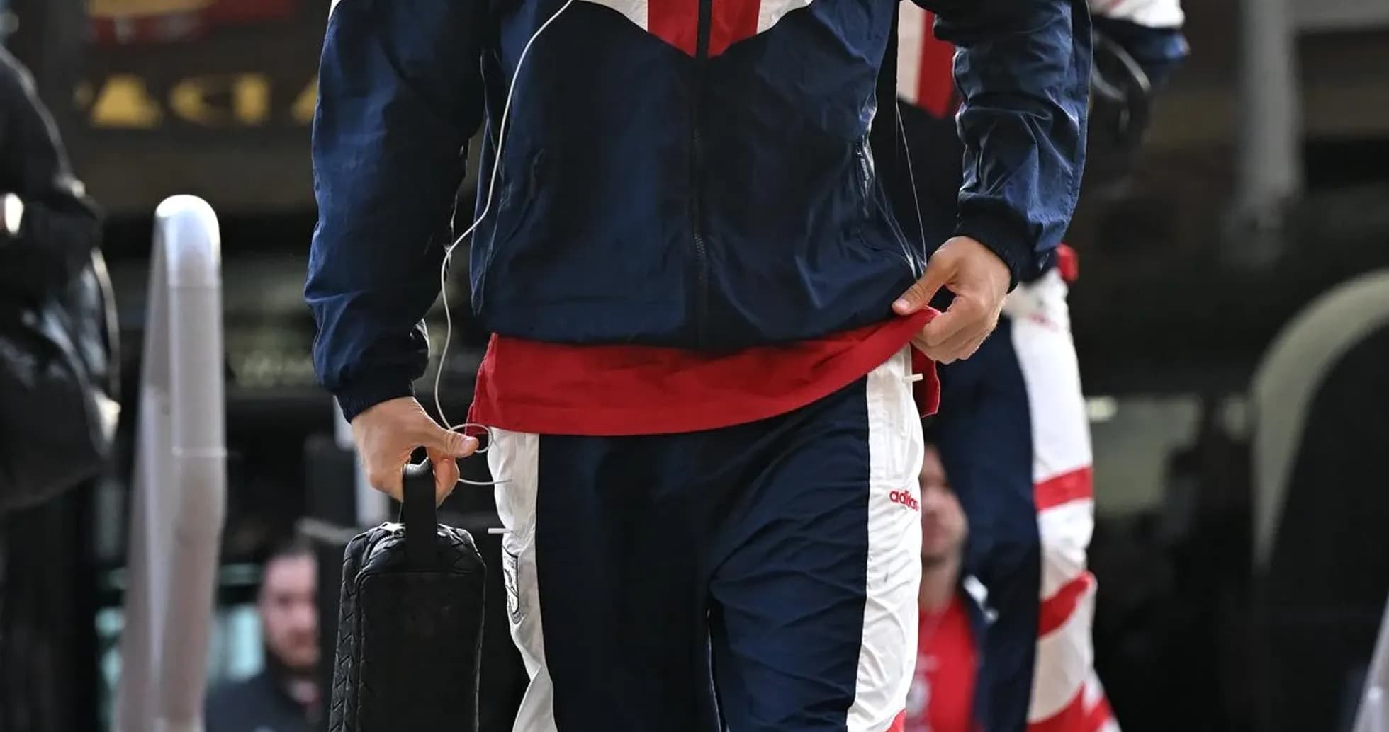 Jugador llegando con ropa de entrenamiento y maletín