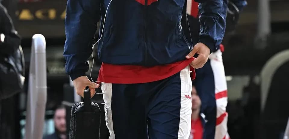 Jugador llegando con ropa de entrenamiento y maletín