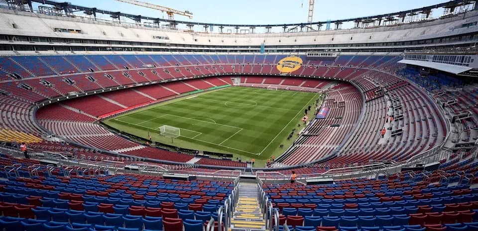 Estadio vacío con césped y gradas coloridas