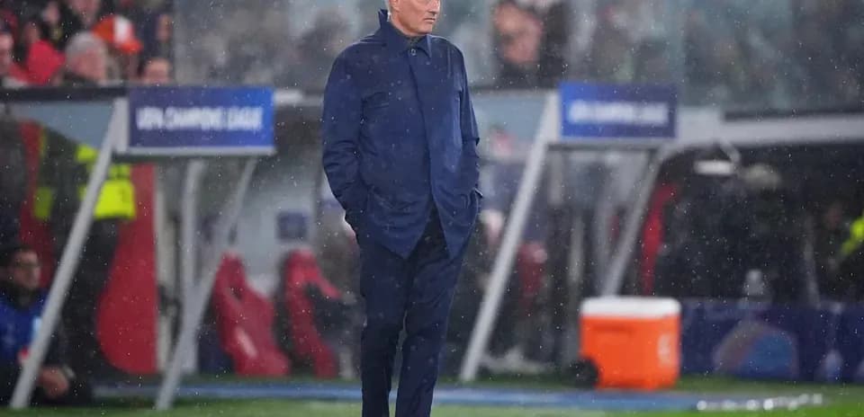 Entrenador en la línea de banda durante un partido lluvioso
