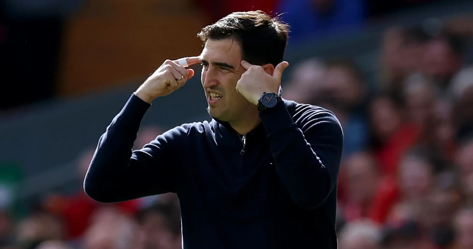 Entrenador gesticulando durante un partido de fútbol