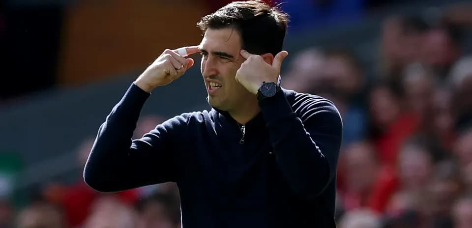 Entrenador gesticulando durante un partido de fútbol