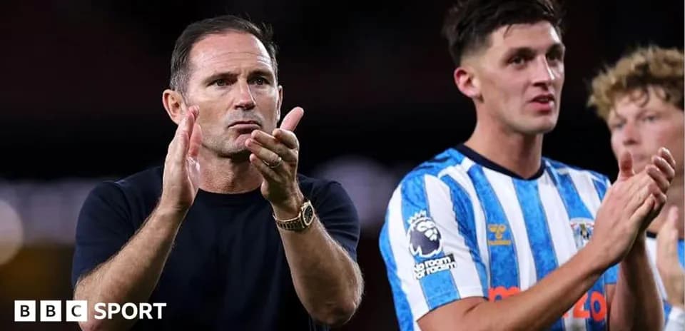 Entrenador aplaudiendo junto a jugador en el campo