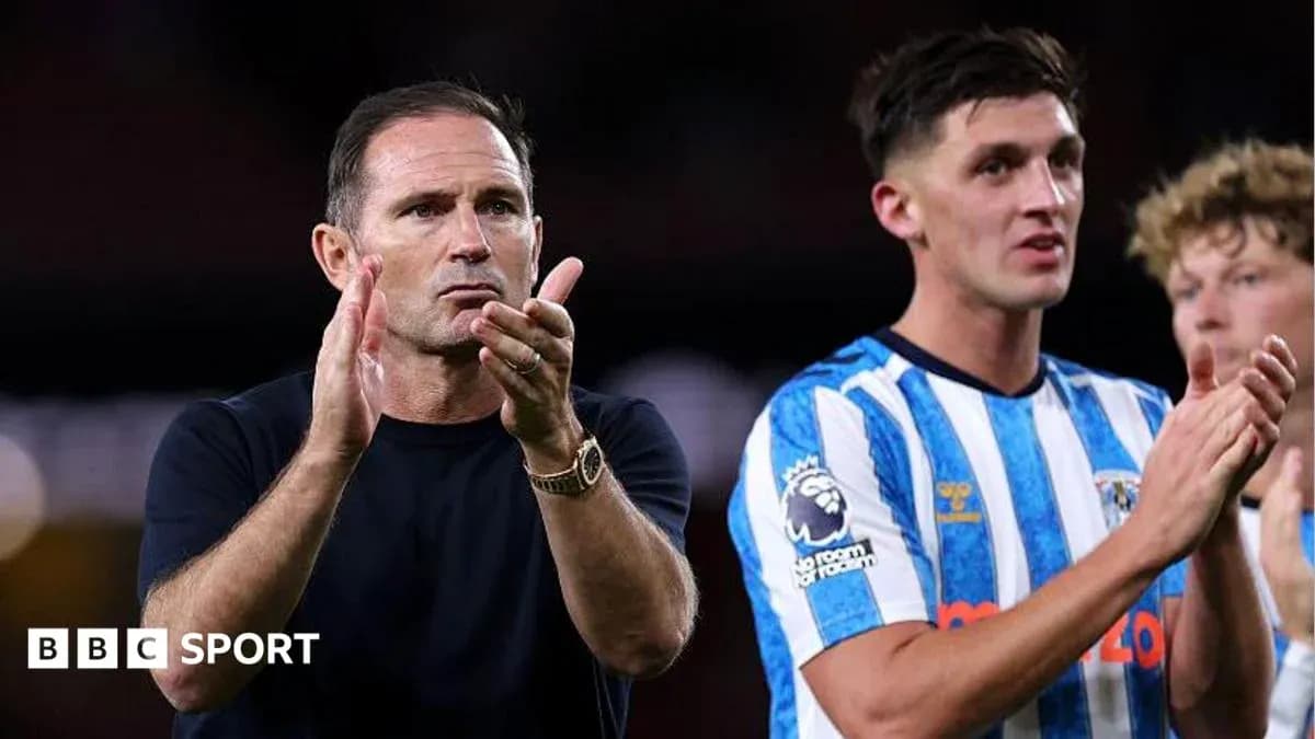 Entrenador aplaudiendo junto a jugador en el campo