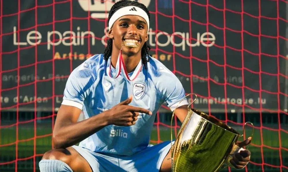 Jugador posando con trofeo en campo de fútbol