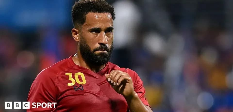 Jugador con camiseta roja en el campo de fútbol