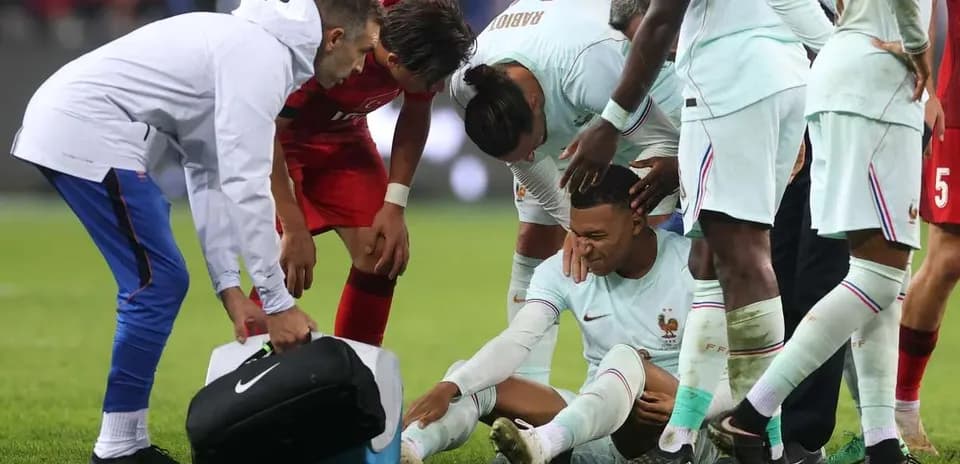 Jugadores rodeando a un futbolista herido en el campo