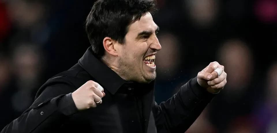 Entrenador celebrando con puños cerrados durante partido