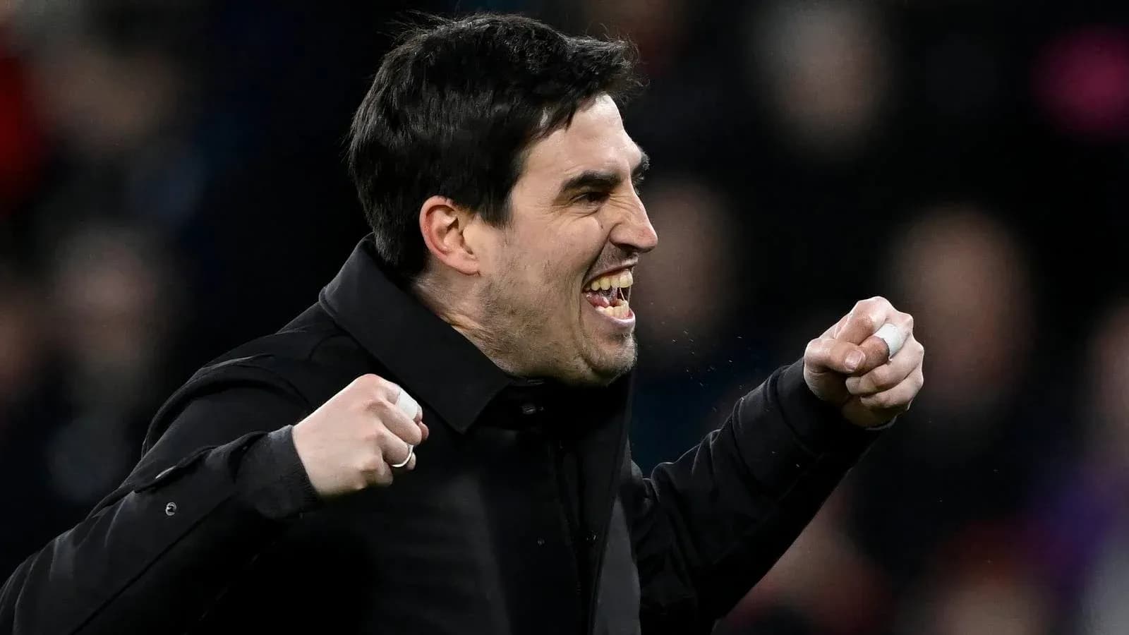 Entrenador celebrando con puños cerrados durante partido