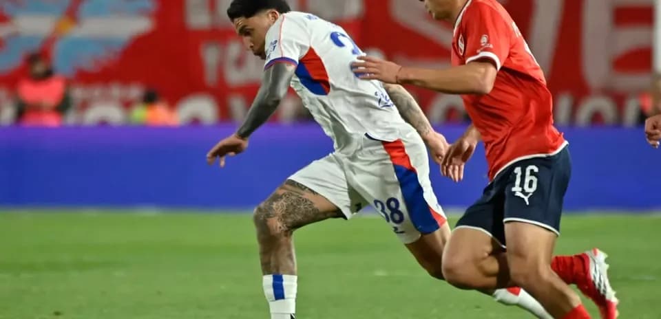 Jugador de San Lorenzo driblando a defensor de Independiente