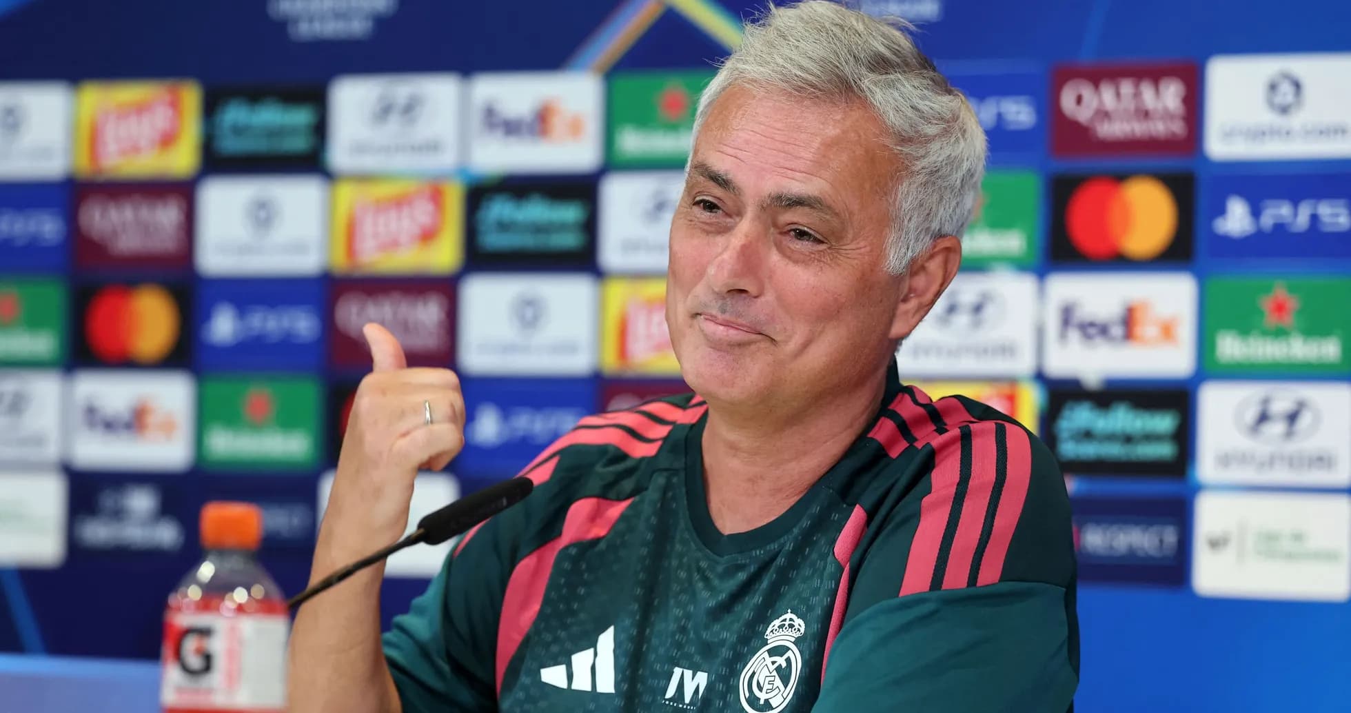 Entrenador en conferencia de prensa con logo de Champions