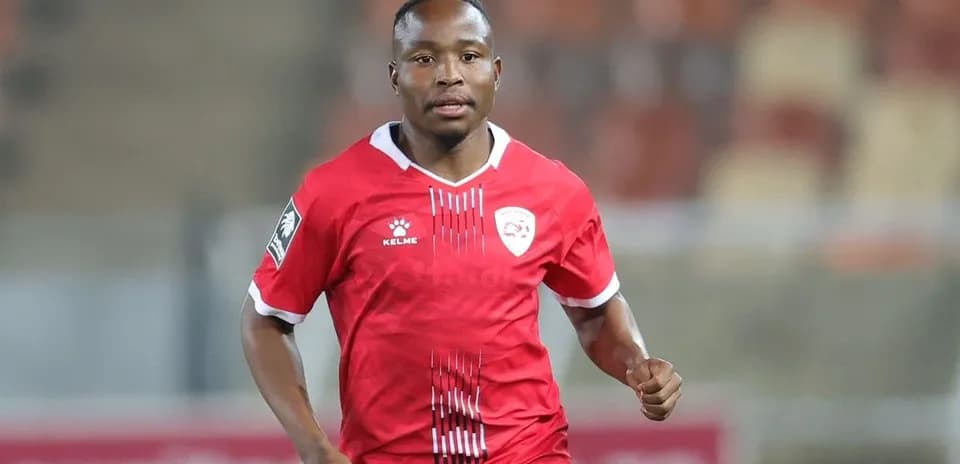 Jugador corriendo con camiseta roja en el campo