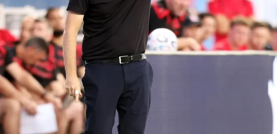 Entrenador dando instrucciones desde la línea de banda