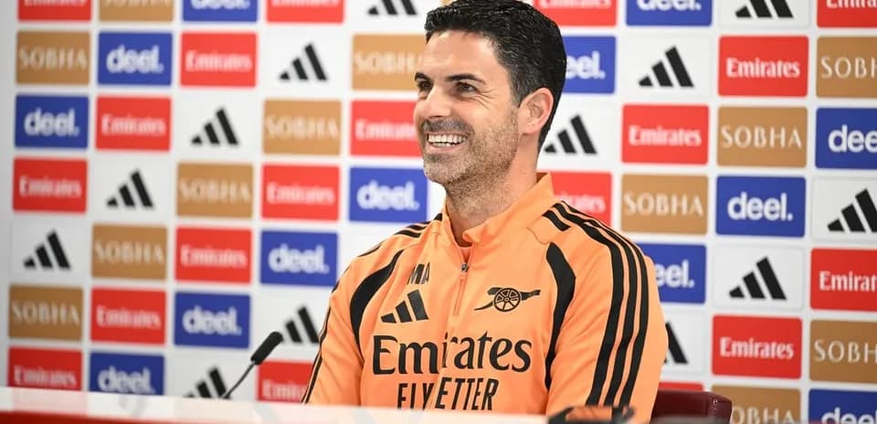 Entrenador en conferencia de prensa sonriendo