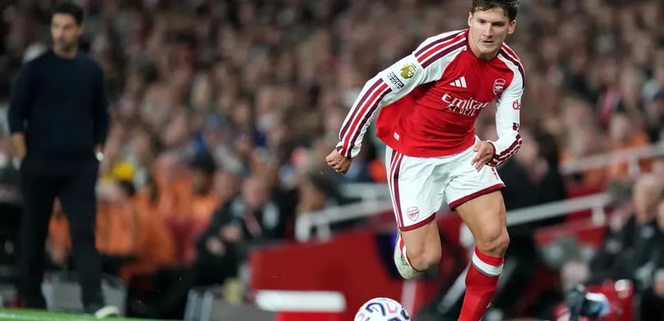Jugador de Arsenal corriendo con el balón en el campo