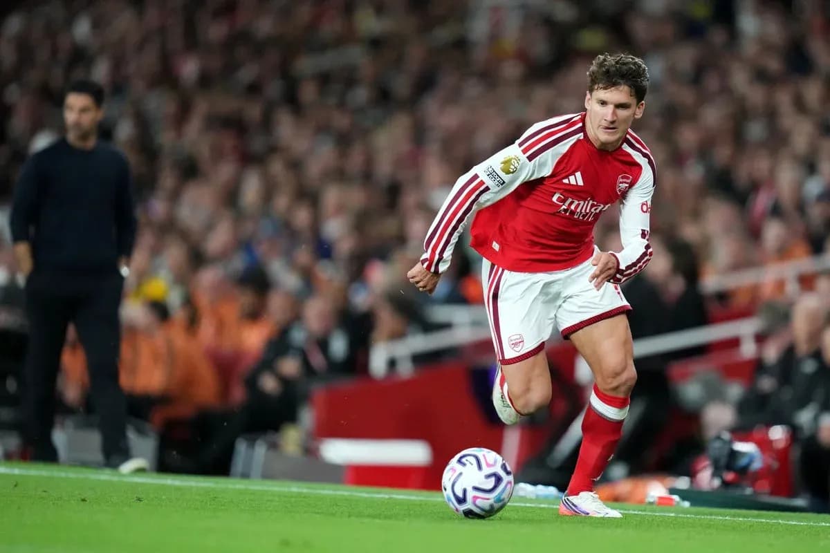Jugador de Arsenal corriendo con el balón en el campo