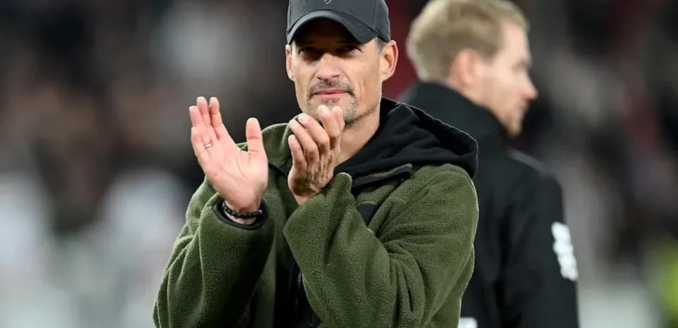 Entrenador aplaudiendo en el campo durante el partido