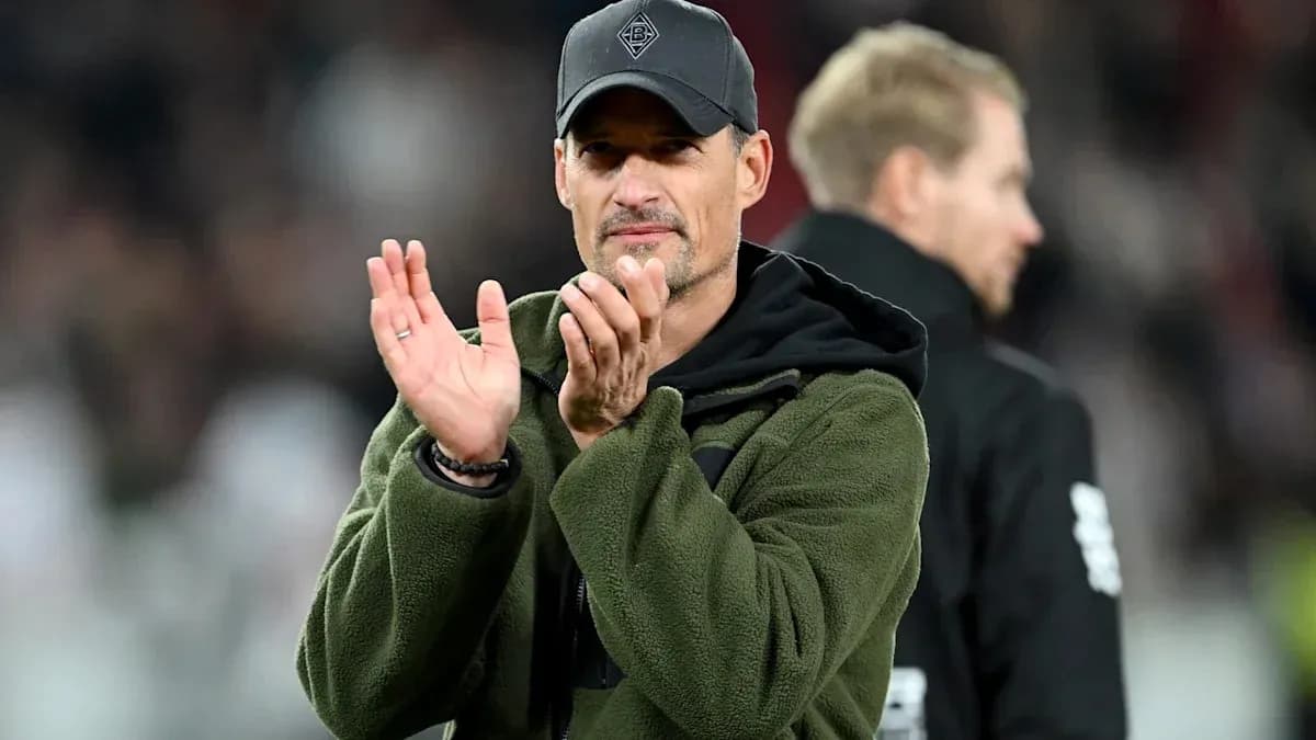 Entrenador aplaudiendo en el campo durante el partido