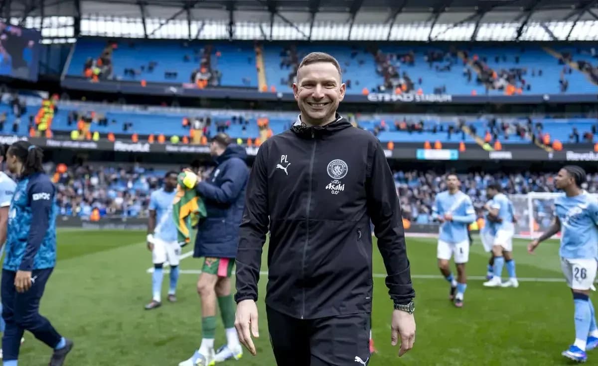 Entrenador sonriente saliendo del campo tras el partido