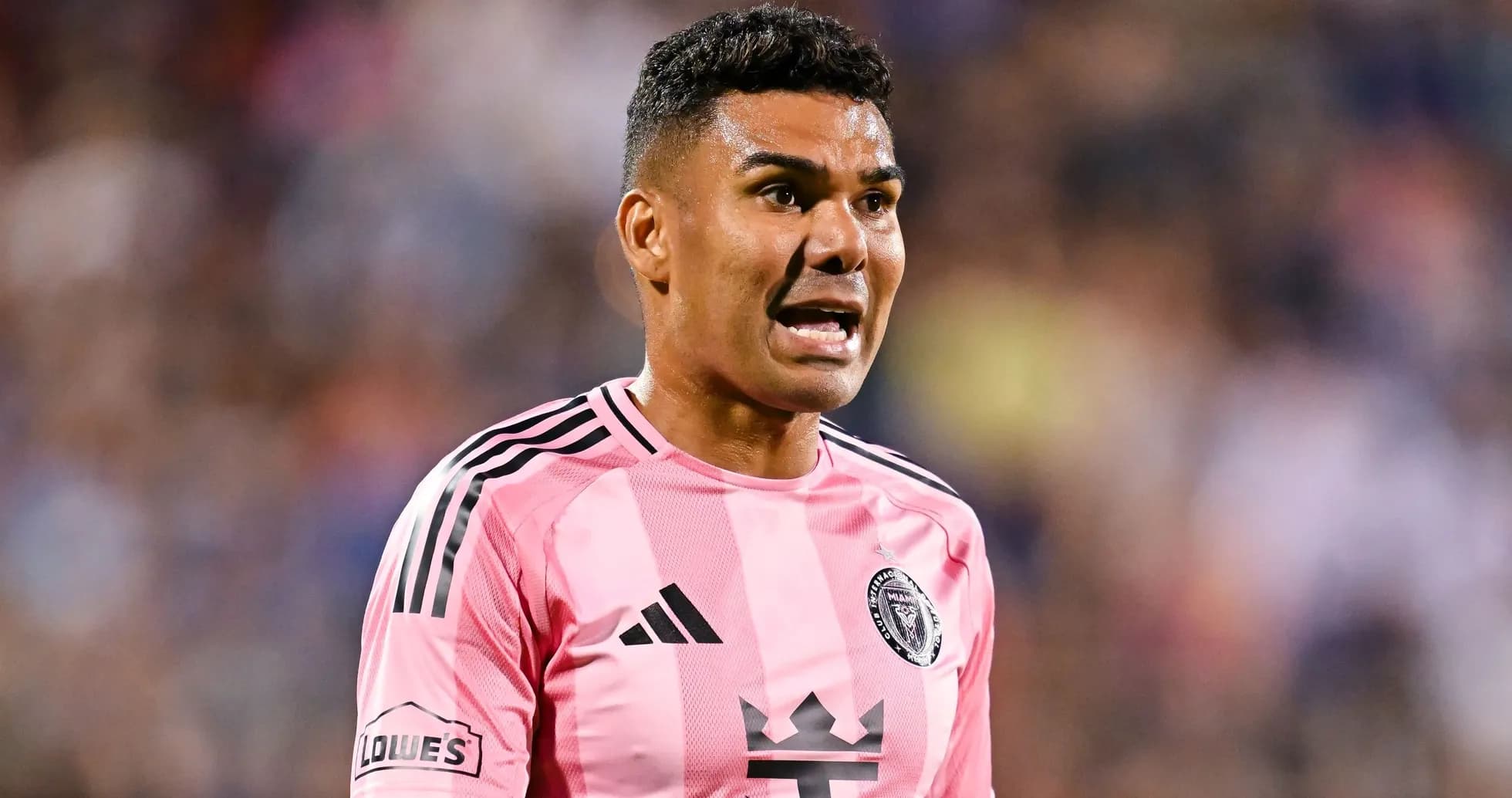 Jugador de fútbol en uniforme rosa hablando en el campo