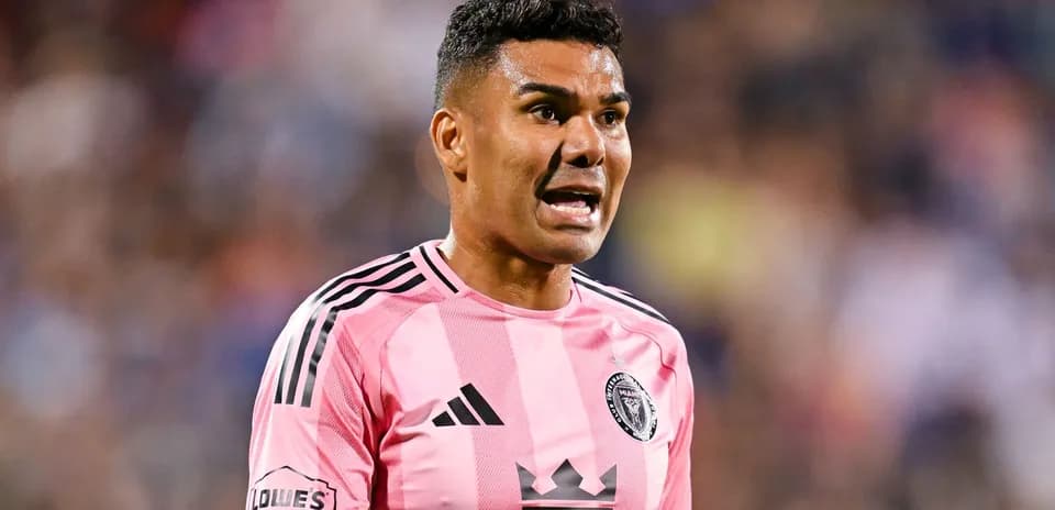 Jugador de fútbol en uniforme rosa hablando en el campo