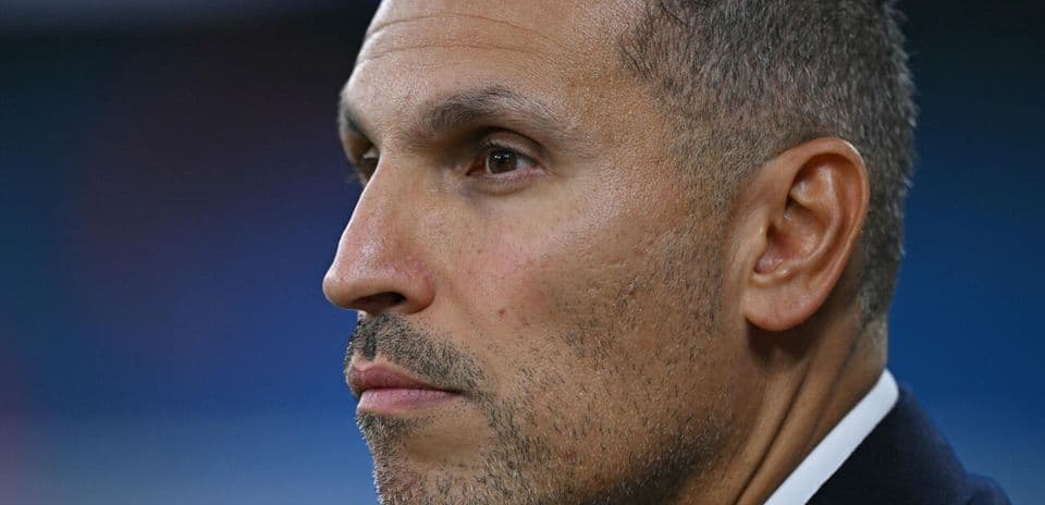 Entrenador observando un partido desde el banquillo