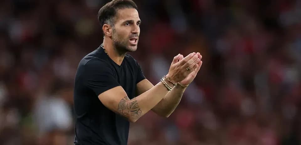 Entrenador dando instrucciones desde la banda del campo