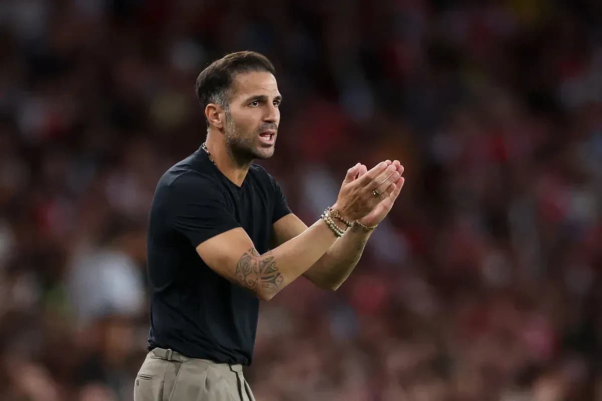 Entrenador dando instrucciones desde la banda del campo