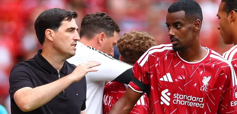 Entrenador hablando con jugador del Liverpool durante partido